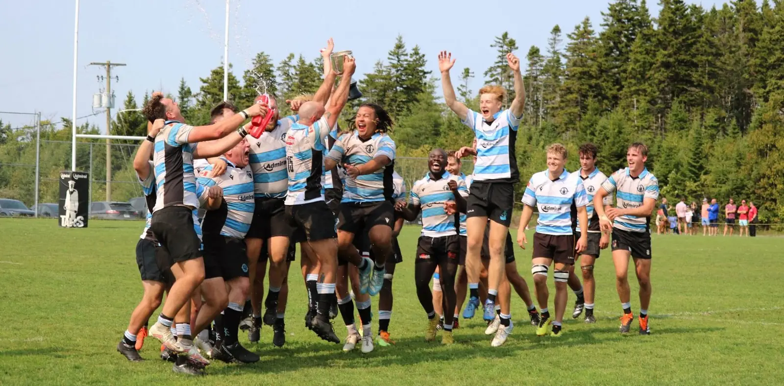 Halifax Tars Division 1 players celebrating on the pitch, cup held aloft