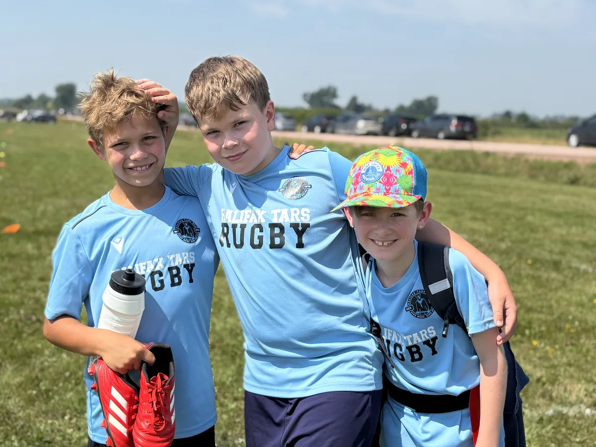 Three young Tars players arm in arm in club shirts
