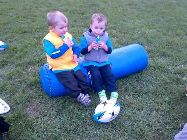 Two toddlers with a rugby ball