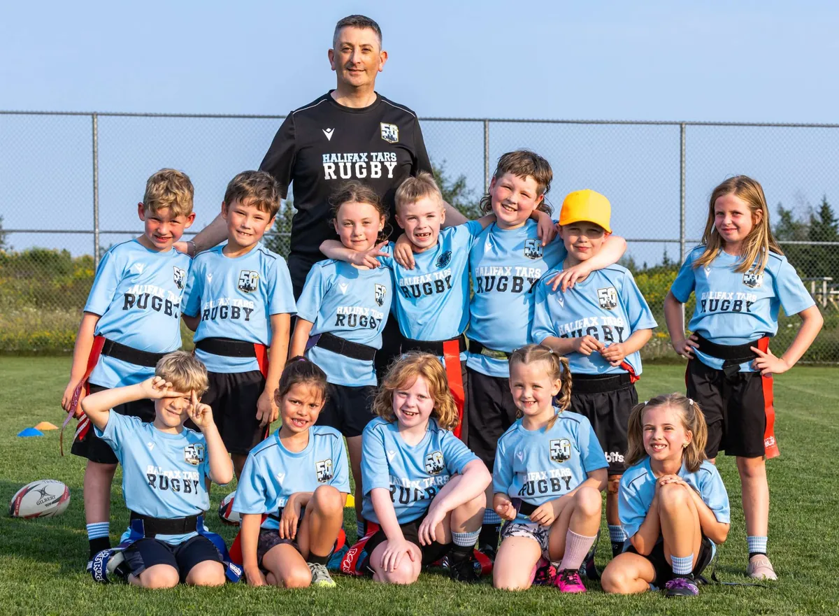 A Tars tag rugby team in their 50th anniversary shirts with their coach